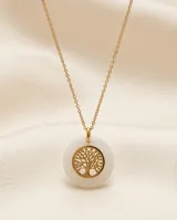Collar de acero con baño de oro, compuesto por una cadena fina y un dije circular que presenta un árbol de la vida dorado en el centro, enmarcado por un borde de cerámica blanca.