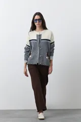Cardigan de tejido jacquard en color azul marino y blanco, con diseño de conejitos en los laterales, cierre frontal con botones y cuello redondo.