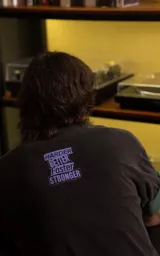 Remera de algodón premium con calce oversize, cuello redondo y mangas cortas. Presenta un estampado gráfico frontal con temática de Daft Punk en tonos verdes y negros.