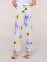 Pantalón ankle de sastrería color blanco con estampado floral multicolor, de corte recto y tiro medio con cordón de ajuste en la cintura.