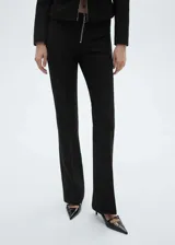 Pantalon de vestir negro con diseño flare, cierre frontal con cremallera metálica visible y corte largo.