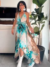 Vestido largo verde con diseño estampado tipo tie-dye y detalles dorados, de corte fluido, un solo hombro y diseño amplio.