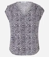 Blusa de crepé estampada en blanco y negro, con escote en V, mangas cortas y detalle de botones en los hombros.