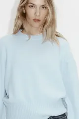Buzo oversized celeste de punto suave levemente cepillado, con cuello redondo, hombros caídos y ribetes acanalados en puños y bajo.