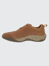 Zapato tipo sneaker de cuero color marrón, con diseño urbano y outdoor. Presenta cordones al tono, puntera redonda y suela de goma con tecnología de amortiguación.