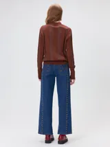 Sweater de punto con diseño de rayas verticales en tonos negro y gris oscuro. Presenta cuello alto tipo polera, mangas largas con puños ajustados y ruedo elástico. Incluye un pequeño bordado en color rojo en el pecho.