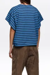 Remera corta de corte amplio confeccionada en 100% algodón, con diseño a rayas horizontales azules y negras, escote redondo, mangas cortas caídas y pequeño logo bordado en el pecho.