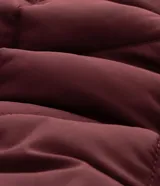 Campera acolchada de color bordó con diseño capitoneado de rombos. Presenta cuello camisero, cierre frontal con broches a presión y dos bolsillos frontales aplicados.