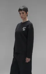 Sweater de cuello redondo color negro, con diseño de calavera bordado en relieve en color blanco en la espalda. Presenta terminaciones en punto rib en cuello, puños y ruedo, con un calce relajado y oversize.