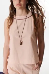 Musculosa blanca de lino con cuello redondo y ribete marrón.
