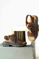 Sandalias de plataforma con suela track, confeccionadas en una combinación de cuero liso y cuero con textura croco. Presentan tiras anchas en el empeine y cierre con hebilla ajustable en el talón.