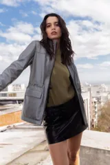 Cazadora plateada con cuello mao, cierre frontal con cremallera, bolsillos laterales con solapa y puños con botón.