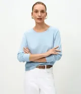 Suéter de punto color marrón chocolate, con cuello redondo y mangas largas con puños acanalados. Presenta un diseño básico y versátil de corte recto.