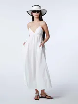 Vestido largo blanco de algodón con breteles finos, escote en V y bolsillos laterales.