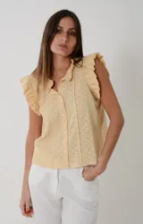 Camisa sin mangas de voile de algodón color amarillo maíz con detalles broderie, cuello mao y volados en los hombros. Cuenta con cierre frontal de botones y diseño romántico.