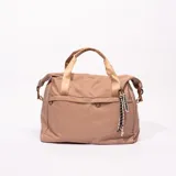 Bolso tipo tote color marrón claro, con doble asa corta color dorado y correa larga ajustable. Incluye un bolsillo externo con cierre y un dije con la palabra 'traveller'.