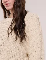 Buzo de algodón blanco con diseño de punto calado y mangas anchas.