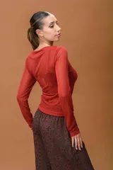 Remera de manga larga confeccionada en tejido de lurex con efecto semitransparente y acabado brillante, de corte ajustado y cuello redondo.