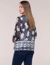 Cardigan abierto con blusa interior blanca, confeccionado en tejido de tul semitransparente con estampado animal print en tonos marrón y blanco, mangas 3/4 y escote redondo con detalles metálicos.