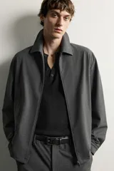 Sobrecamisa regular fit color gris, con cuello solapa, manga larga con puño abotonado, bolsillos de vivo en la cadera y cierre frontal con cremallera de doble dirección.