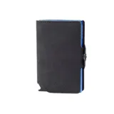 Billetera compacta Baleine modelo Kansas, con exterior de cuero negro y estructura interna de aluminio azul con sistema deslizante para tarjetas. Incluye tecnología RFID para protección de datos y compartimentos adicionales para billetes y documentos.