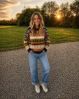 Sweater de lana merino con estampado Fair Isle en tonos azul marino, beige, naranja, verde oliva y bordó. Tiene cuello redondo y mangas largas.