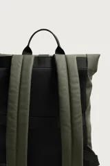 Mochila técnica de acabado engomado en color negro. Presenta un diseño de solapa con cierre de hebilla de liberación rápida y un sistema de cordones elásticos frontales. Incluye compartimento para dispositivos electrónicos, espalda acolchada y correas ajustables.