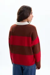 Sweater de tejido de punto con diseño a rayas horizontales anchas en color rojo y marrón oscuro. Posee cuello polo de color blanco y tapeta con botones.