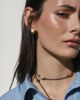 Aros pequeños de bronce con forma irregular y acabado liso, estilo huggie o argolla gruesa.