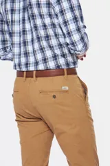 Pantalón marrón claro de corte skinny, con bolsillos laterales y traseros, confeccionado en tejido flexible con spandex.