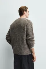 Cárdigan de punto con textura acanalada, corte relajado, cuello en pico y cierre frontal con botones. Confeccionado en tejido con lana, presenta mangas largas y acabados en rib.