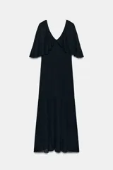 Vestido largo de punto color negro, con escote en V pronunciado tanto en el delantero como en la espalda, y mangas cortas anchas con vuelo.