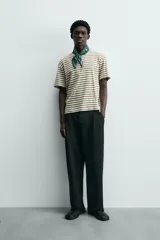 Camiseta de manga corta con cuello redondo y calce relajado, confeccionada en tejido de rayas horizontales blancas y negras.