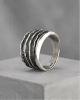 Anillo de plata 925 con acabado empavonado, diseño de banda ancha con relieve de líneas onduladas horizontales.