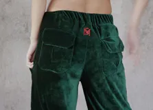 Pantalón cargo de terciopelo verde oscuro, de corte holgado, cintura elástica y bolsillos con solapa en la parte trasera. Cuenta con detalle de bordado rojo en la parte superior.