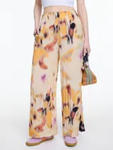 Pantalón de pierna ancha confeccionado en viscosa crinkled con estampa de manchas en tonos naranja, marrón y negro. De calce relajado y cintura con elástico.