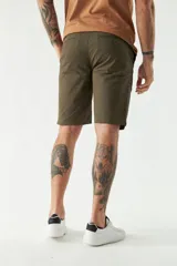 Bermuda tipo chino de gabardina con cierre de cremallera y botón, bolsillos laterales y traseros, y pasacintos en la cintura.