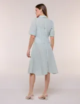 Vestido camisero midi de rayas blanco y verde, con cuello solapa, escote en V, mangas cortas y falda acampanada con vuelo.