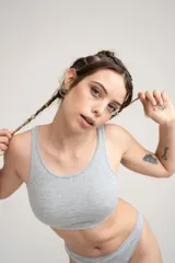 Top tipo deportivo sin aro, de color gris melange, confeccionado en algodón y elastano.