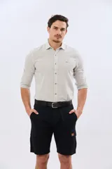 Bermuda cargo de gabardina en color gris oscuro, corte recto, con bolsillos laterales con solapa y cierre de botones y cremallera.