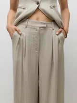 Pantalón sastrero de tiro alto color beige, con cierre de gancho y cremallera, bolsillos laterales y un fit relajado. Confeccionado en tejido chambray.