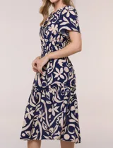 Vestido midi azul marino con estampado floral grande en color beige, escote en V con cuello mao, mangas cortas, cintura fruncida con elástico y falda con volados en niveles.