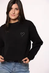 Buzo tejido de punto color negro, con cuello redondo, mangas largas y detalle de corazón bordado con brillos en el pecho.