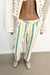 Jeans rectos de tiro bajo, confeccionados en denim con diseño de rayas verticales en tonos amarillo, celeste y rosado, estilo cropped, con cierre frontal de cremallera y botón metálico, presillas para cinto y clásico diseño de cinco bolsillos.