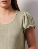 Remera tejida con estampado animal print, de manga corta con detalle de puntilla en las mangas y cuello redondo.