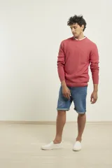 Sweater de punto fino azul con cuello redondo y terminaciones elásticas en canalé.