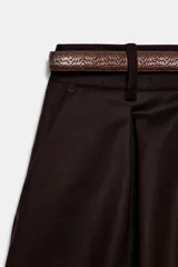 Bermuda de tiro medio color marrón con pinzas delanteras y cierre frontal. Incluye un cinturón fino a juego con hebilla metálica.