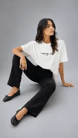 Remera oversize blanca de calce relajado, con cuello redondo, mangas cortas y bordado frontal con la frase "The New Cool Cruda".