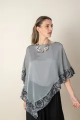 Blusa irregular en gasa de seda natural color gris, con zócalo en tul bordado en color gris plata.