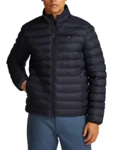 Campera puffer Tommy Hilfiger color azul marino, con cuello alto, cierre frontal con cremallera, bolsillos laterales con cremallera y logo bordado en el pecho.